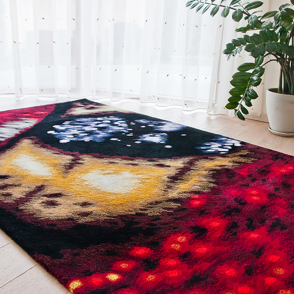A hand tufted area rug with butterfly wing motif